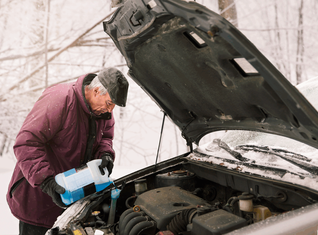 Un monsieur qui met de l'antigel dans sa voiture